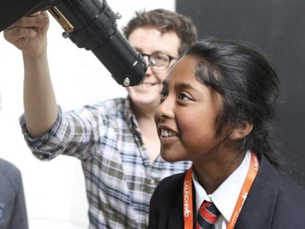 A girl looking through a telescope